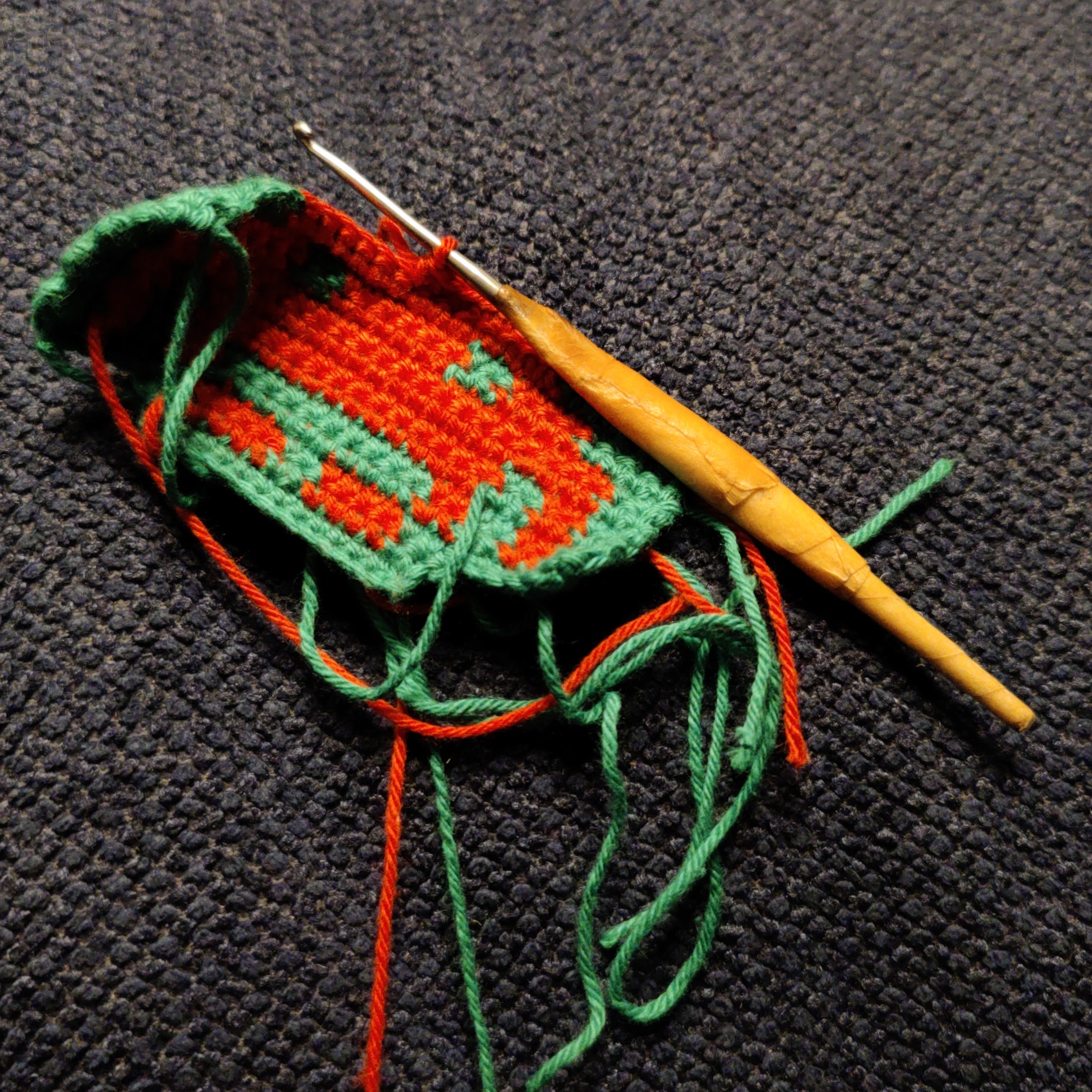 A half-made crocheted space invader